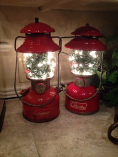 two red lanterns with plants in them sitting on a counter