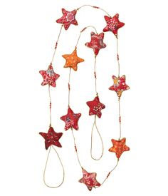 red and orange stars are hanging from a string on a white background, with beads attached to the strings