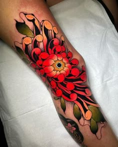 a woman's leg with flowers and leaves on it