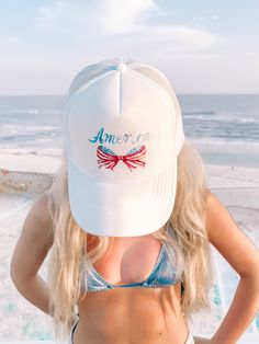 Get patriotic and stylish with the America Bow Hat from Sassy Shortcake! This white, trucker style hat features a mesh design, text that reads america, and a bow made of the American flag. Show off your love for the USA in a unique and playful way. Sassy Shortcake, The American Flag, Design Text, Mesh Design, Sierra Leone, Mauritius, How To Make Bows, Caribbean Netherlands, Laos