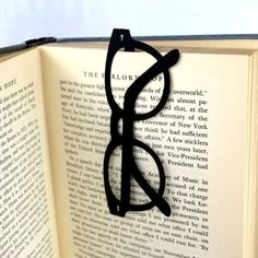 an open book with black glasses on it