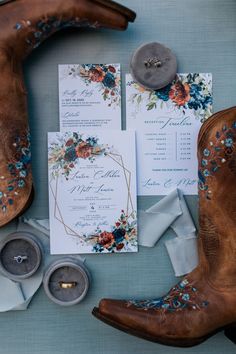 the wedding stationery is laid out with cowboy boots