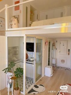 an apartment with white walls and wooden flooring is shown in this image, there are plants on the table