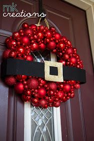 a christmas wreath is hanging on the front door with a belt around it's waist