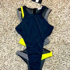 Iconswim Dark Grey Cut Out Swimsuit. Size Small. New With Tags. Grey Swimsuit Featuring Green And Grey Strap Detailing. Runs True To Size Double-Lined Cheeky Coverage Bottoms Swim Fabric: 86% Nylon, 14% Spandex Model Is Wearing A Small Sleeveless Color Block Swimwear For Beach, Sleeveless Color Block Swimwear For Beach Season, Trendy One Pieces For Poolside And Beach Season, Trendy One-pieces For Poolside And Beach Season, Trendy Sleeveless One Piece For Pool, Trendy Sleeveless One-piece For Pool, Beach Nylon Swimwear With Cutout, Cutout Nylon Swimwear For Pool, Cutout Swimwear For Summer Pool