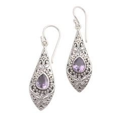 These pretty dangle earrings from Dewi Putera in Bali showcase all that is traditional to Balinese jewelry including the motifs known as jawan (tiny silver granules or dots) and bun (curled silver wire). The leaf-like shapes even call to mind the kawung motif one of the oldest Javanese batik motifs. Sparkling drops of amethyst grace the dangle earrings. Purple Earrings With Intricate Design As Gift, Purple Earrings With Intricate Design For Gift, Ornate Purple Sterling Silver Earrings, Traditional Silver Drop Jewelry, Traditional Engraved Teardrop Earrings, Traditional Purple Dangle Earrings, Purple Traditional Earrings For Gift, Traditional Purple Teardrop Jewelry, Traditional Sterling Silver Drop Jewelry