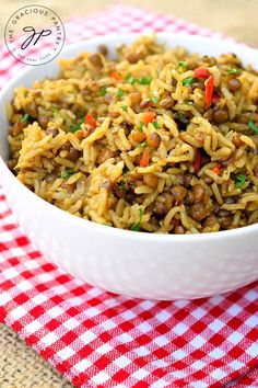 instant pot lentils and rice in a white bowl on a red checkered tablecloth