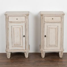 two white wooden cupboards sitting next to each other on top of a hard wood floor