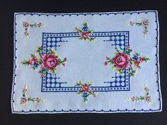 a blue cloth with pink flowers on it and a white border around the edges that have been stitched together