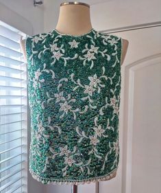 "1960's green sequins top with all over white floral beading and beaded trim. Beaded on wool shell and lined with green nylon. Lining appears to have been added by last owner and has been hand stitched on top. You may want to remove it or add your own as it appears slightly baggy and needs to be re-sewn around on one armpit (see pics). Back metal zipper closure. I can find no missing beads or sequins, in beautiful condition. Marked a size large. Has some slight stretch to it. Flat Measurements: Green Evening Gowns, Sequins Top, Chiffon Cocktail Dress, Green Sequins, Vintage Style Dresses, Top Floral, Beaded Trim, Sweet Dress, Tops Fall