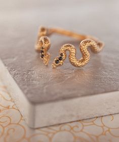 Fab and Sophisticated snake band in Bohemian Chic style. The snake texture inspired by mystical alchemical Ouroboros snake, which is one of the traditional infinity symbols. It has comfort fit and you won't want to take it off! About this item: -Flipped Black diamonds. 0.05 total carat weight --Solid 14K Rose/Yellow/White Gold OR -Solid 18K Rose/Yellow/White Gold PLEASE NOTICE: This price is for the ring's sizes up to 8, if you need a bigger size > contact us for price & details! Please a Adjustable Snake Ring In Yellow Gold, Unique Snake-shape Wedding Ring, Luxury Adjustable Snake Ring, Adjustable 14k Gold Snake Ring, Luxury Adjustable Snake Ring For Gift, Luxury Adjustable Snake Ring Gift, Wedding Ring Black Diamond, Gothic Wedding Ring, Snake Texture