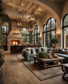 a living room filled with lots of furniture next to large windows and a fire place