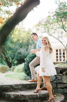 a man and woman walking up some steps