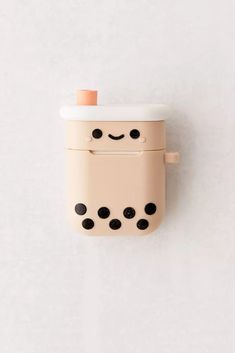 an adorable little toy with black dots on it's face and eyes is hanging from the wall