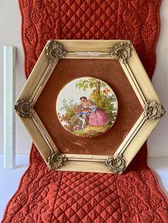 there is a plate with a painting on it in the shape of a hexagonal frame