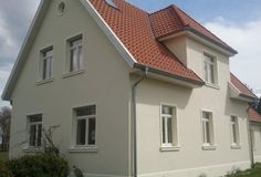 a white house with red tile roof and windows