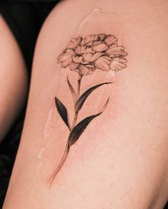 a woman's thigh with a flower tattoo on it