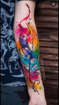 a colorful feather tattoo on the arm