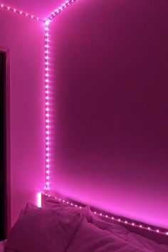 a bedroom with pink lights on the walls