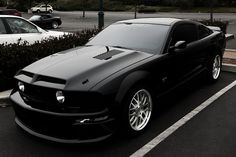 a black sports car parked in a parking lot