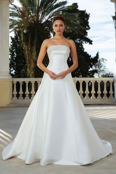 a woman in a white wedding dress posing for the camera with her hands on her hips