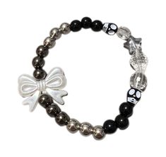 Elevate your alternative style with this unique Gothic Skull Bead Bracelet, featuring a striking combination of black and silver beads, accented with a cute bow charm. Perfect for those who love edgy, goth, and kawaii-inspired fashion, this stretch bracelet is a versatile piece that easily slips on and off for everyday wear. Each bracelet is handmade with care, blending classic gothic elements with a touch of playful charm. If you like the bracelet without the bow charm, I can make one without t Alt Bracelets, Emo Bracelets, Goth Bracelets, Dr Bedroom, Skull Bead Jewelry, Alternative Fashion Jewelry, Gothic Elements, Gothic Bracelet, Goth Accessories