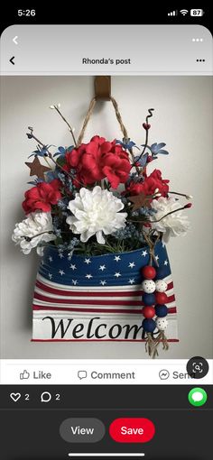 an american flag bucket with flowers hanging on the wall in front of a sign that says welcome