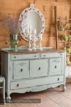 an old dresser has flowers and candles on it