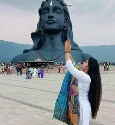 a woman touching the head of a large statue