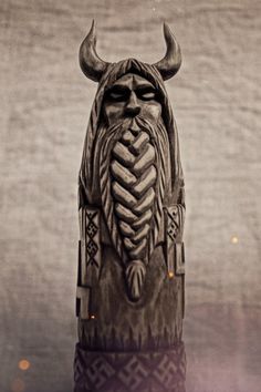 a wooden statue with horns on it's head and an intricately carved face