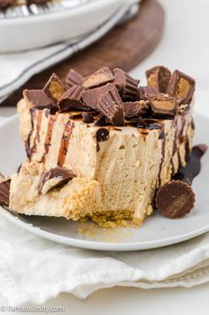 a piece of cheesecake on a white plate with chocolate and caramel toppings