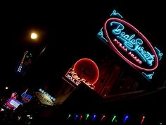 several neon signs are lit up in the dark