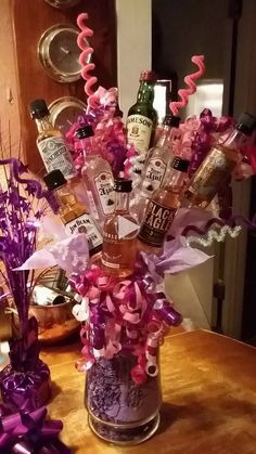 a vase filled with lots of bottles on top of a table