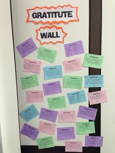 a bulletin board with post - it notes attached to the front door that says, gratitue wall