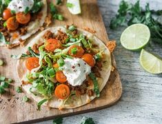 two tortillas topped with shredded carrots, sour cream and cilantro