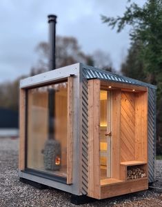 a small wooden sauna sitting on top of gravel