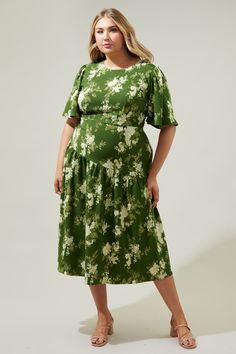 An ethereal floral print takes on a timeless silhouette with a modern taste. The Vetiver Floral print features bright, summer motifs that sit against a green-ground that decorates the Rhythm midi. A dress that features flouncy short sleeves that frame a flattering, fitted bodice that maintains a sleek fit throughout the waist, nearing the hips. A drop waist, asymmetrical skirt sits low on the hips, reminiscent of the twenties and thirties. Wear it with kitten heels and your fave bag.- Drop waist Green A-line Midi Dress With Floral Print, Green A-line Floral Dress For Garden Party, Green Floral Print Midi Dress, Green Floral Short Sleeve Dress For Summer, Green Floral Short Sleeve Dress For Brunch, Green Printed A-line Midi Dress, Green Printed Midi Dress For Garden Party, Garden Party Green Printed Midi Dress, Green Floral Print A-line Midi Dress