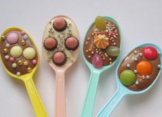 five spoons with different types of candies in them