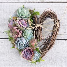 a heart shaped wreath with succulents on it