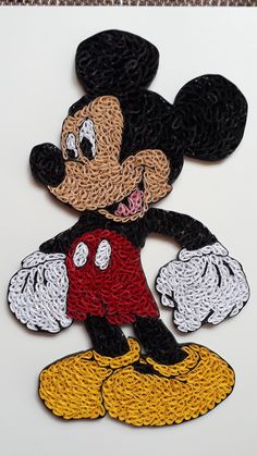 the mickey mouse is made out of crochet and has been stitched on to it