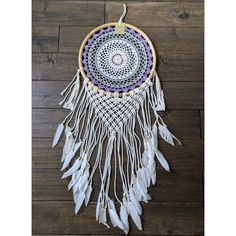 a white and purple dream catcher on a wooden floor