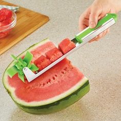 a watermelon slice being cut into pieces with a sharp knife on the end