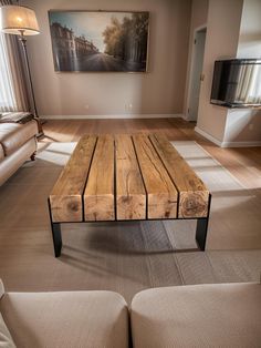 a wooden table sitting in the middle of a living room next to a couch and tv