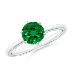 a ring with an emerald green stone in the center