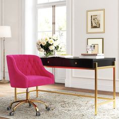 a pink chair sits in front of a desk with a black top and gold legs