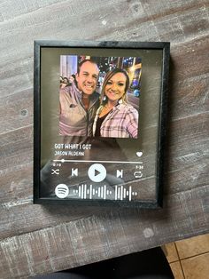 a wooden table topped with an mp3 player next to a couple's face on it