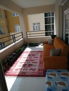 an orange couch sitting on top of a balcony