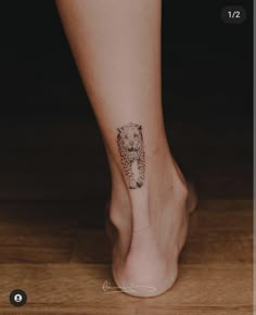 a woman's foot with a small bear tattoo on her left leg and the word love written across it