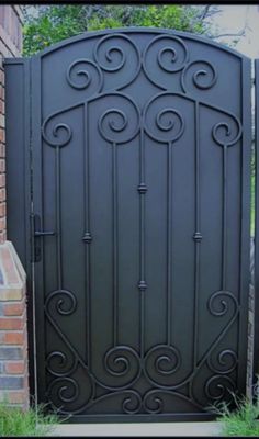 an iron gate in front of a brick building