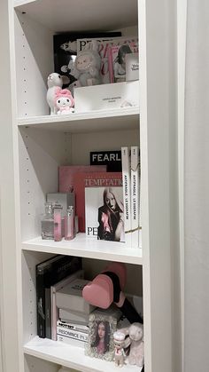 a white book shelf filled with lots of books and other stuff on top of it